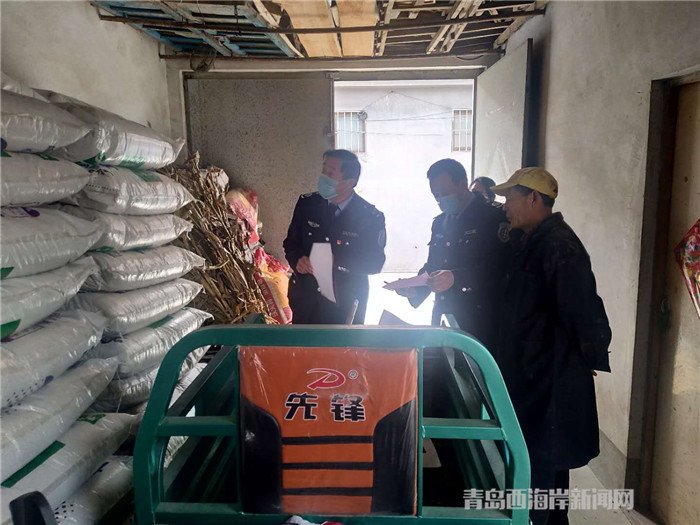圖為西海岸新區(qū)農業(yè)綜合行政執(zhí)法大隊執(zhí)法隊員在檢查肥料經營情況。.jpg